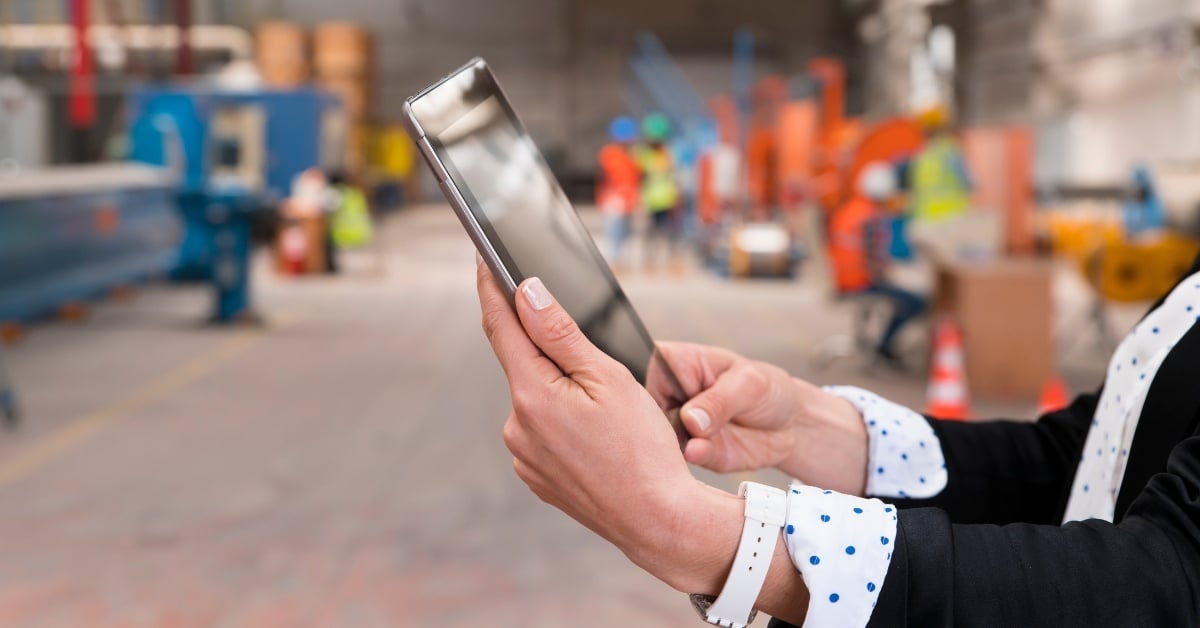 Business Person Checking a Tablet Device in a Warehouse